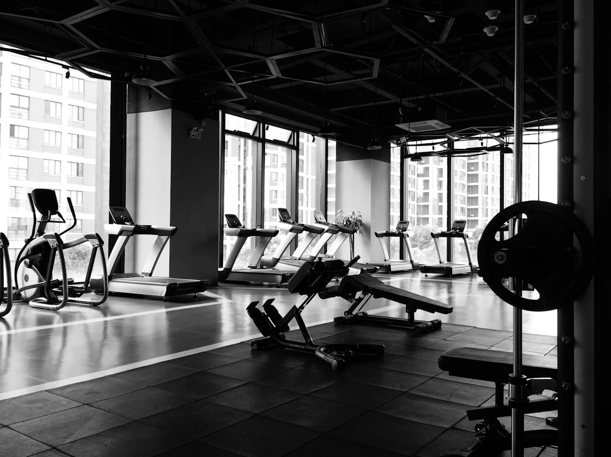 Area gym modern dengan deretan treadmill dan peralatan kebugaran